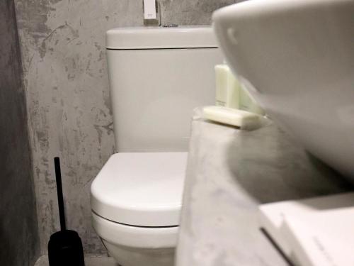 bagno con servizi igienici bianchi e lavandino di Mon Cheri Clarens a Clarens