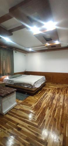Habitación con cama y suelo de madera. en Shan stay Home, Near wonder la No, en Bangalore