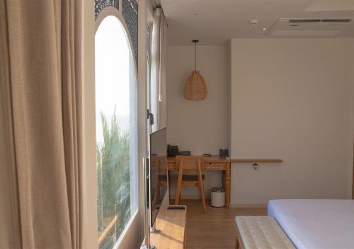 a room with a bed and a desk with a window at Stone Hotels Dhiffushi in Dhiffushi