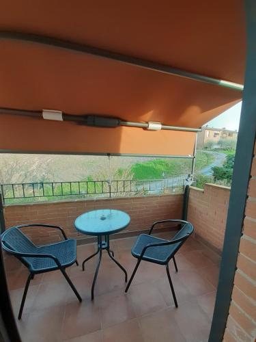 a patio with two chairs and a table and a window at B&B La Verbena in Siena