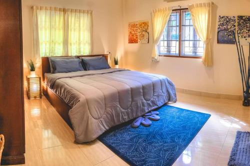 - une chambre avec un grand lit et un tapis bleu dans l'établissement cross 9, à Ban Thalat Choeng Thale