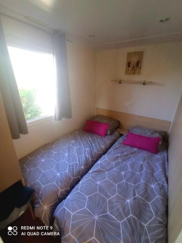 une chambre avec deux lits et une fenêtre dans l'établissement CAMPING / LOCATION MOBIL HOME : Les gorges du Verdon et lac de Sainte Croix., à Sainte-Croix-de-Verdon