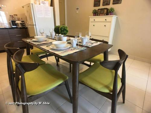 Il dispose d'une cuisine et d'une table à manger avec des chaises vertes. dans l'établissement Homestay @ Subang Jaya KTM & LRT + High Speed INET, à Subang Jaya