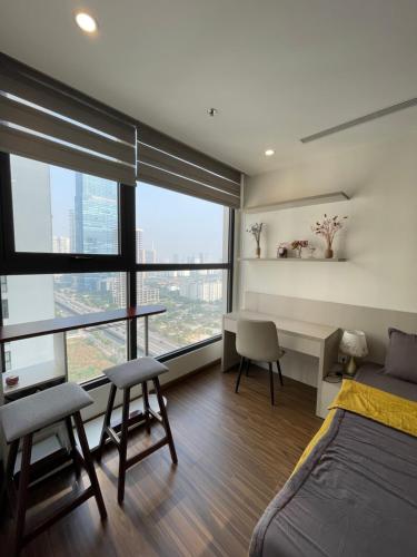 a bedroom with a bed and a desk and some windows at Vinhomes West Point Studio W1-2510 in Hanoi