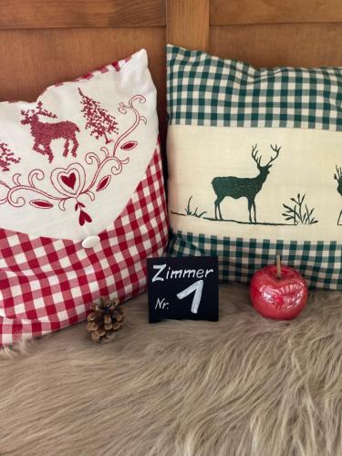 a bed with pillows and an apple and a sign at Auersberg Haus in Eibenstock