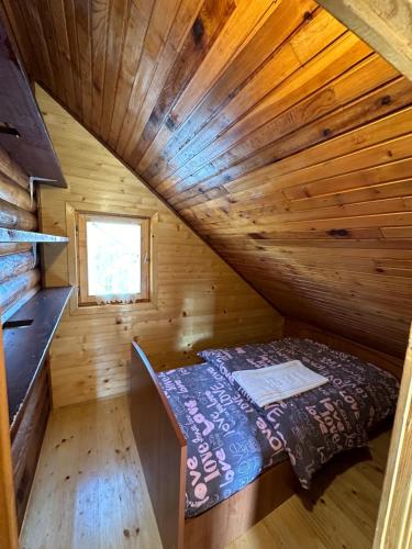 an attic room with a bed in a wooden cabin at Breza in Žabljak