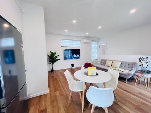 uma sala de estar com uma mesa e cadeiras e um sofá em Double storey, Walk to Showground em Melbourne