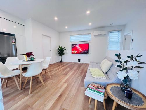 uma sala de estar com um sofá e uma mesa em Double storey, Walk to Showground em Melbourne