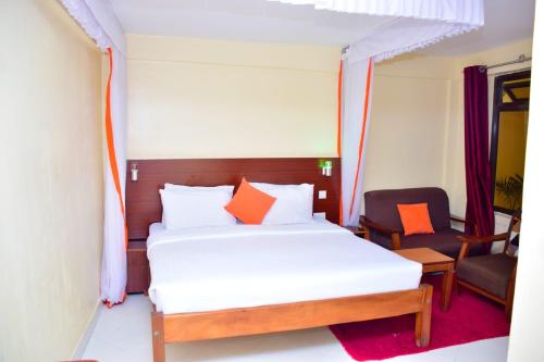 a bedroom with a bed with orange pillows at Olive Hotel Narok in Narok