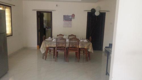 a dining room with a table and four chairs at SPALON Holiday Home in Hyderabad