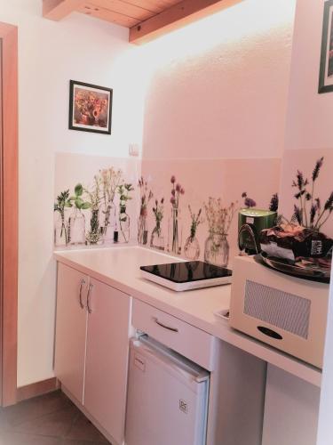 a kitchen with flowers in vases on a counter at FerienAppartments Landhaus FühlDichWohl in Fehring