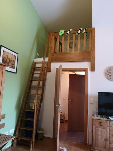 a loft bed in a room with a staircase at FerienAppartments Landhaus FühlDichWohl in Fehring