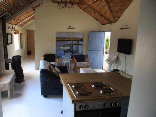 a kitchen with a stove and a living room at Fishermansrest in Velddrif