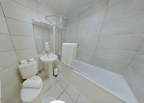 a white bathroom with a toilet and a sink at 3 Bed - Close to City Centre, LGI and Uni of Leeds - Long Stay Rates in Headingley