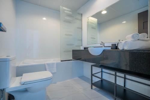 uma casa de banho branca com um lavatório e um WC em Budget Friendly Production City em Dubai