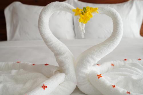 two swans made out of towels on a bed at One Beach Resort By EHM in Koh Rong Sanloem