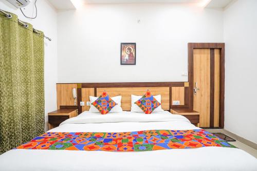 a bedroom with a large bed with a colorful blanket at FabHotel Vairagi inn in Varanasi