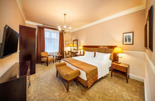 プラハにあるEsplanade Hotel Pragueのベッドとテレビが備わるホテルルームです。