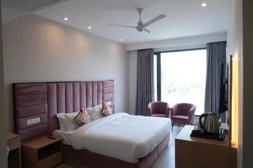 a hotel room with a bed and a television at ACR Luxury Hotel in Mohali
