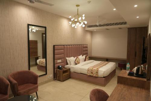 a bedroom with a large bed and a mirror at ACR Luxury Hotel in Mohali
