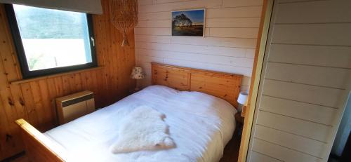 um pequeno quarto com uma cama branca num camarote em Le Petit Idéal em Leykaul