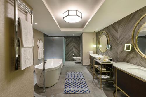 a bathroom with a tub and two sinks and a mirror at Elite World Grand Sapanca in Sapanca