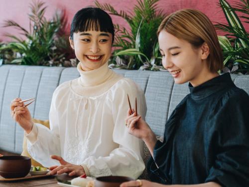 two women sitting at a table eating food at Prince Smart Inn Miyazaki in Miyazaki