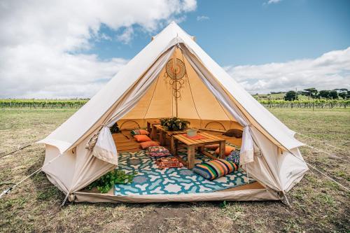 a white tent with a table in a field at Coastal Glamp at Bellarine Estate winery in Bellarine