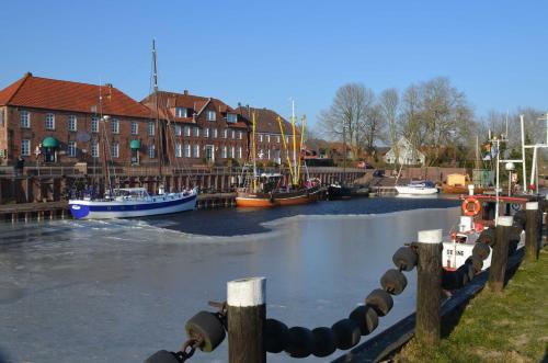 a group of boats are docked in a river at Fischerhaus in Hooksiel