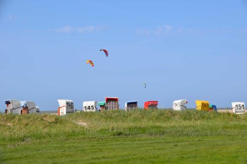 a kite flying over a bunch of trailers in a field at Haus Deichblick 1 in Hooksiel