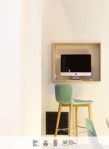 a room with a chair and a tv on a wall at SLEEP'N Atocha - B Corp Certified in Madrid