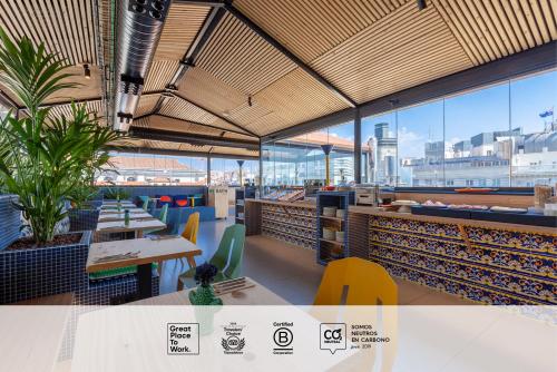 a restaurant with tables and chairs and windows at SLEEP'N Atocha - B Corp Certified in Madrid