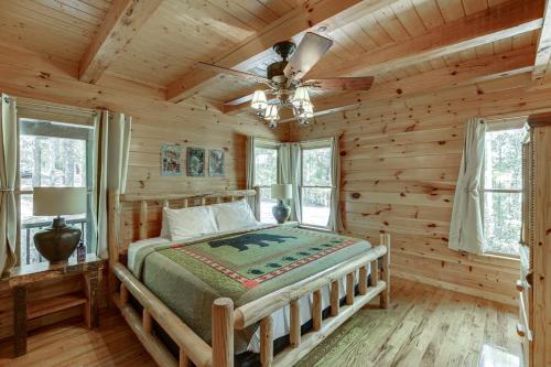 - une chambre avec un lit dans une cabane en rondins dans l'établissement Deluxe Cabin For Groups Near Helen w Hot Tub, à Cornelia