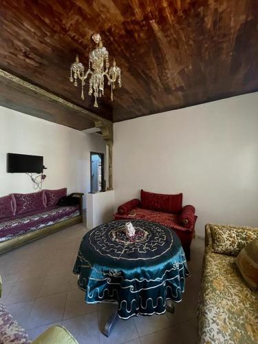 een woonkamer met een tafel en een bank bij Route de la jnane awrad lotissement 14 immeuble 5 étage 4 appartement 20 Marrakech in Marrakesh