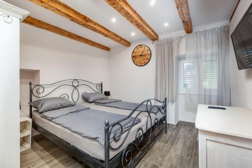 a bedroom with a bed and a clock on the wall at Villa 1900 in Kornić