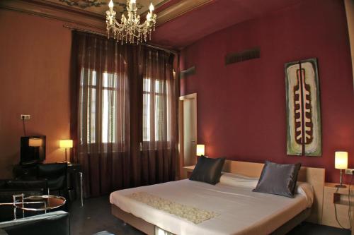a bedroom with a large bed and a chandelier at Hotel Sant Roc in Solsona