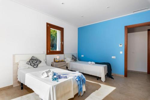 - une chambre avec 2 lits et un mur bleu dans l'établissement Villa Natura - PlusHolidays, à Calp