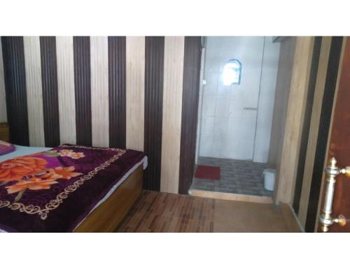 um quarto com um chuveiro, uma cama e uma banheira em Hotel Priya, Ghanghariya em Pāndukeshwar