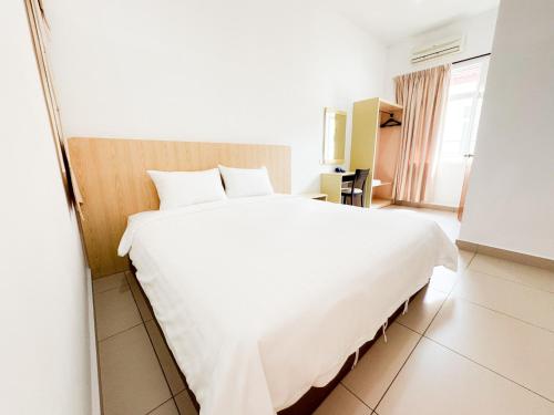 uma grande cama branca num quarto de hotel em De Harmony Stay em Malaca
