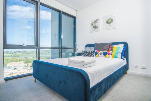 niebieskie łóżko w pokoju z dużymi oknami w obiekcie Minimalism modern apartment*waterview*parking＊IGA w mieście Sydney