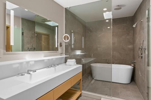 a bathroom with a tub and a sink and a bath tub at SA Carbon Beach Suites in Malibu