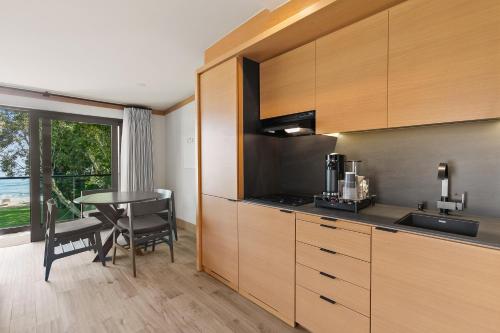 a kitchen with wooden cabinets and a table and a window at SA Carbon Beach Suites in Malibu