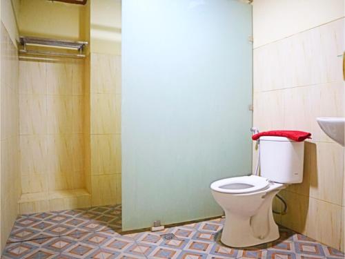 uma casa de banho com um WC, um chuveiro e um lavatório. em D'Hans Hotel em Surabaya