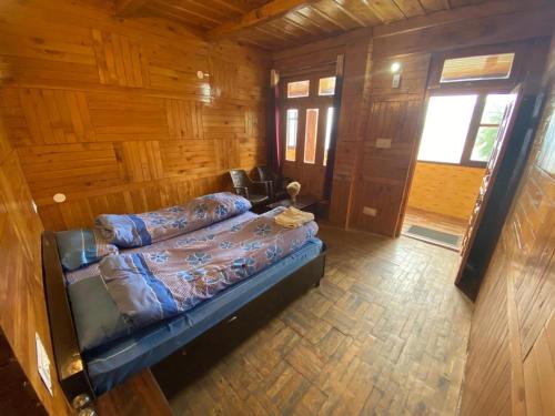 um quarto com uma cama num chalé de madeira em Kiran Home Stay em Shoja