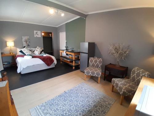 a bedroom with a bed and a desk and chair at Wilgerboom in Paarl