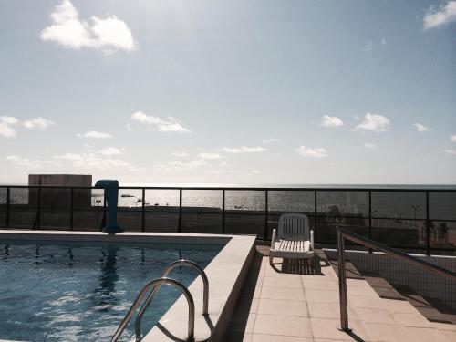 a swimming pool with a view of the ocean at Apartamento Tambaú in João Pessoa