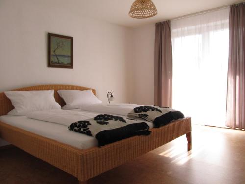 - une chambre avec un lit en osier dans une pièce dotée d'une fenêtre dans l'établissement Ferienwohnung Bluhm, à Weilheim in Oberbayern