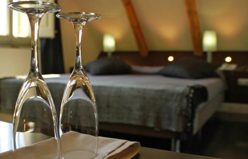 two wine glasses sitting on a table in front of a bed at Hotel Sant Roc in Solsona