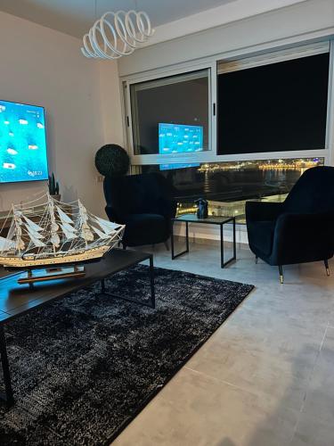 una sala de estar con una mesa con un barco. en Sea View en ‘Akko