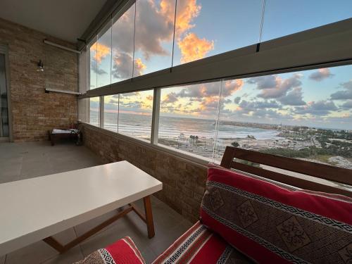 een kamer met een tafel en uitzicht op de oceaan bij Sea View in Akko